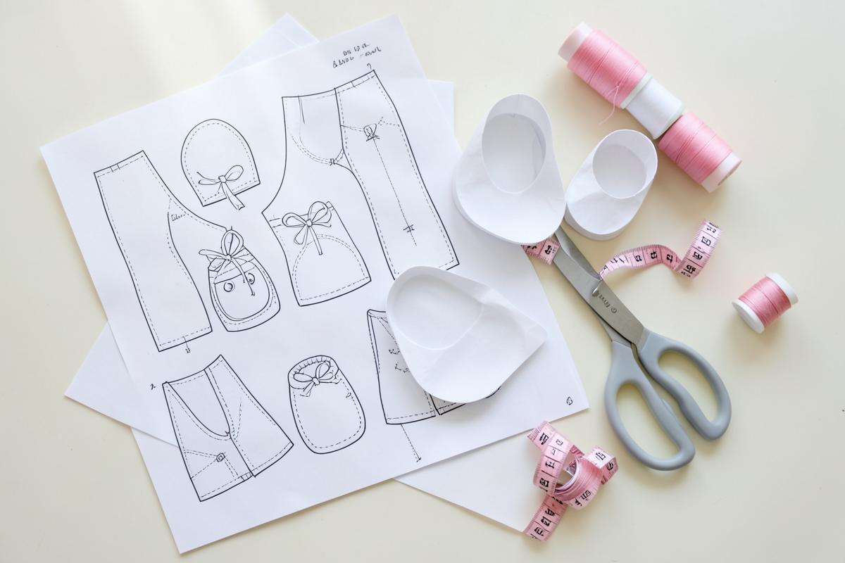 Moldes de papel para sapatinhos de bebê com tesoura, fita métrica e linhas